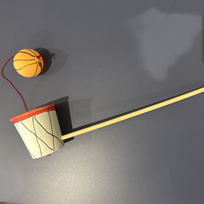ball catch toy made from plastic basketball, paper cup, string and wooden dowel