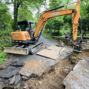 photo of a backhoe digging up a road