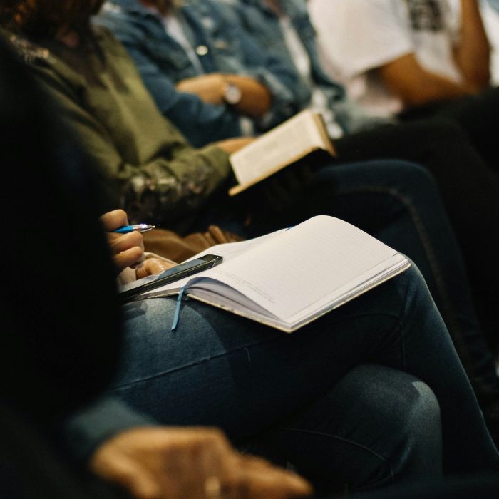 people seated in a circle with journals on their laps