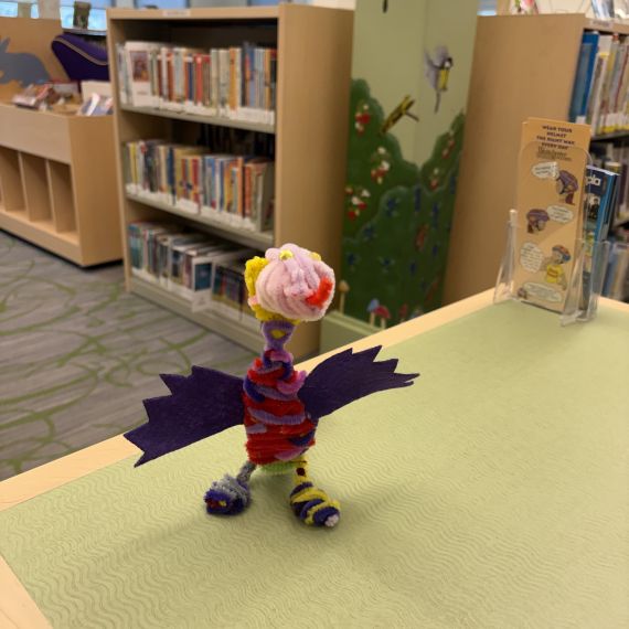 dragon made from colored pipe cleaners and wings cut from purple felt