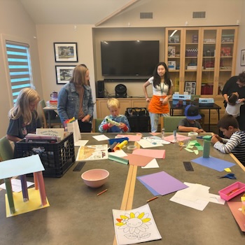 Children gathered around a table doing various projects