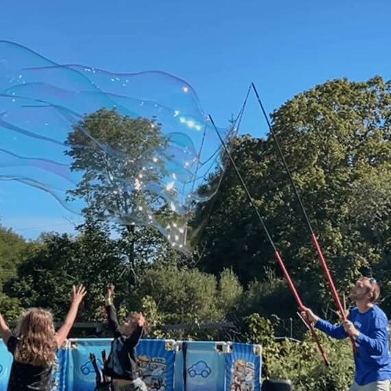 Image of children playing outdoors under a bubble show.
