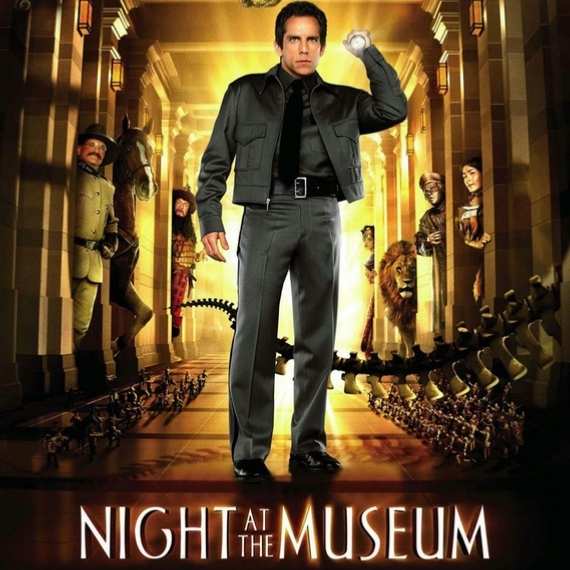 Movie poster for Night at the Museum featuring a man pointing a flashlight at the camera with museum exhibits behind him