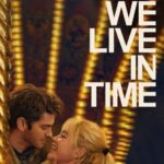 Movie poster for We Live In Time with a man and woman embracing in front of lights.