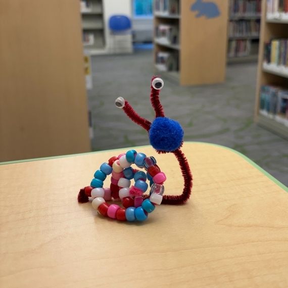 A snail model made out of pipe cleaners and beads