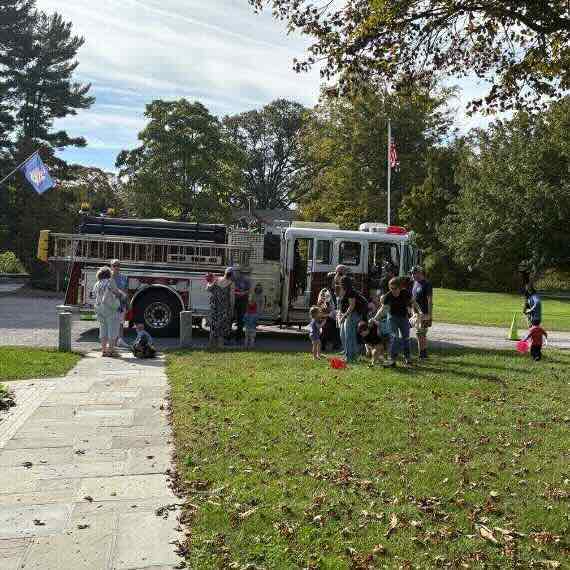 Fire engine surrounded by young children and their parents