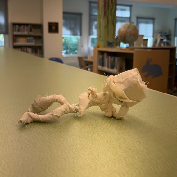 A small mummy doll lying on a table