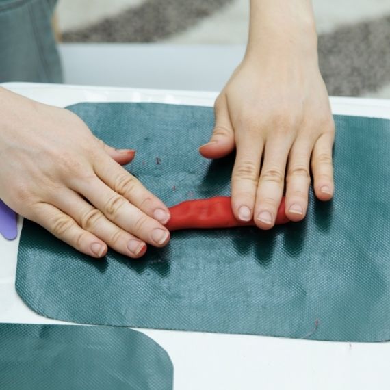 Hands rolling out Play Doh on surface