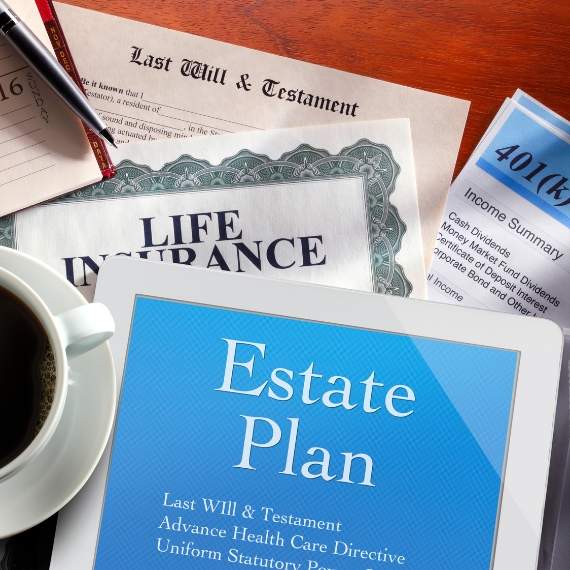 Various documents titled "Estate Plan" and "Life Insurance" and "Last Will and Testament" scattered on top of table.