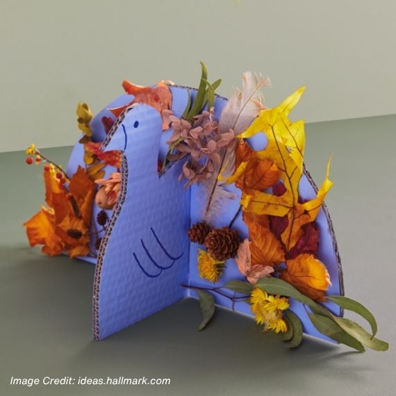 Turkey model created with cardboard pieces with orange leaves stuck on.