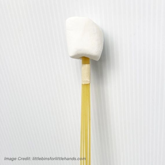 Uncooked spaghetti taped together with a marshmallow on top